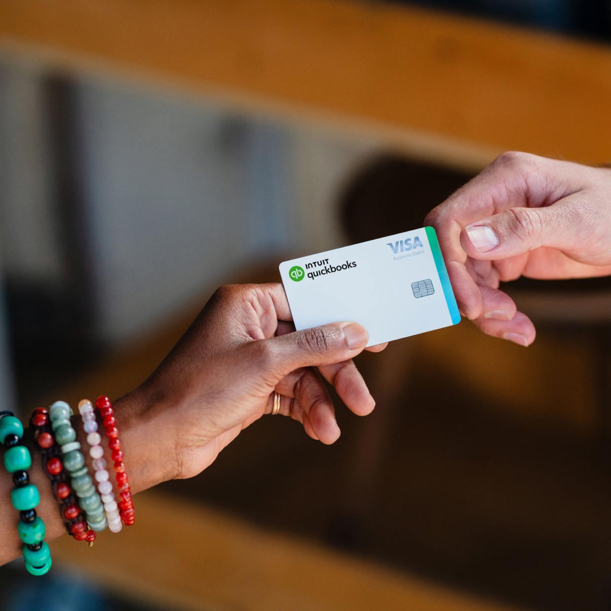A woman uses her QuickBooks Money debit card to pay. 