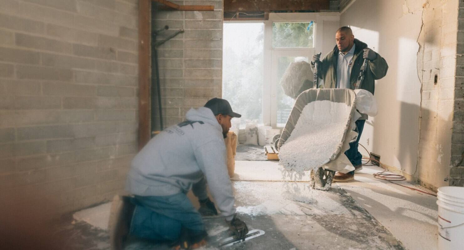Small business workers pouring concrete at a job site.